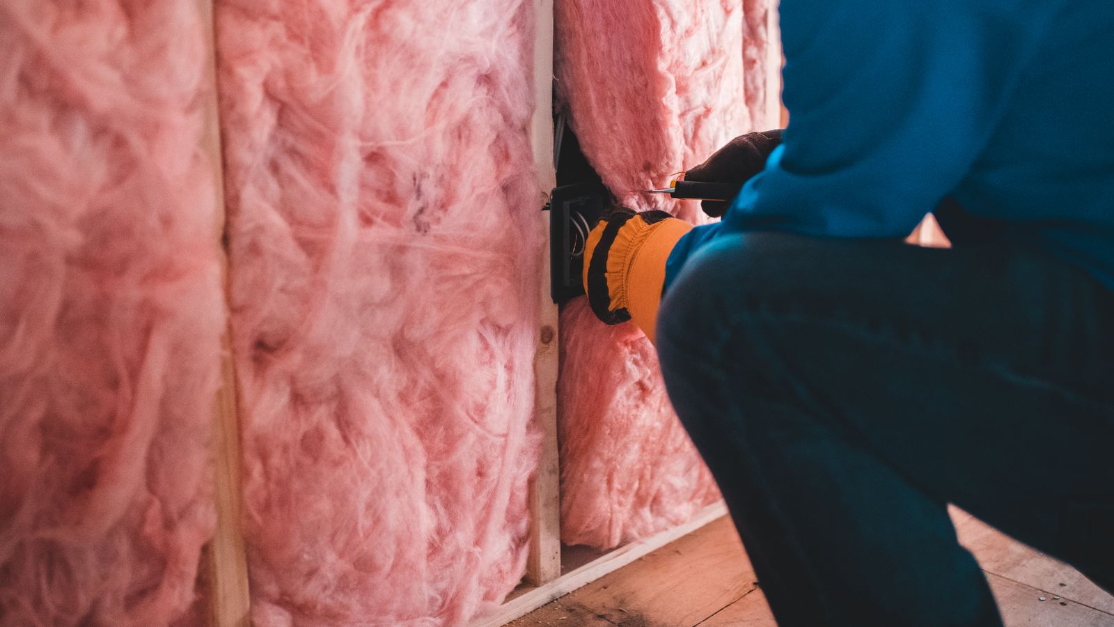 Artisan réalisant l'isolation des murs pour améliorer le DPE d'un logement après travaux de rénovation énergétique