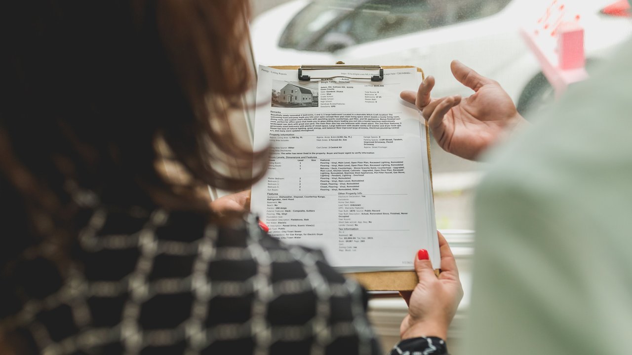 Professionnel tenant un dossier de documents immobiliers lors d'un diagnostic